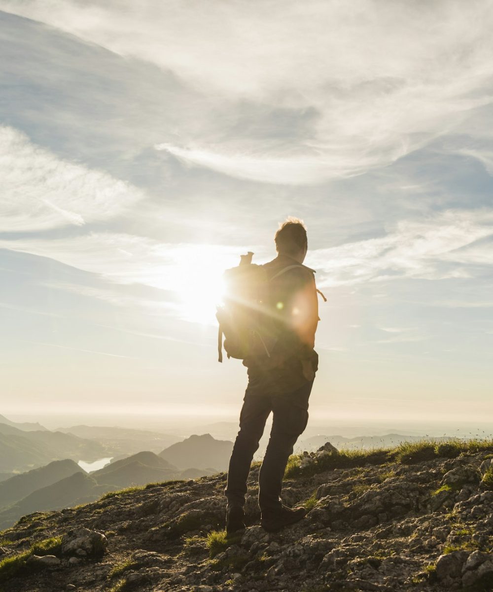 Austria, Salzkammergut, Hiker standing on summit, looking at view Austria, Salzkammergut, Hiker standing on summit, looking at view